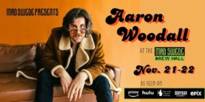 Comedian Aaron Woodall sitting on a couch